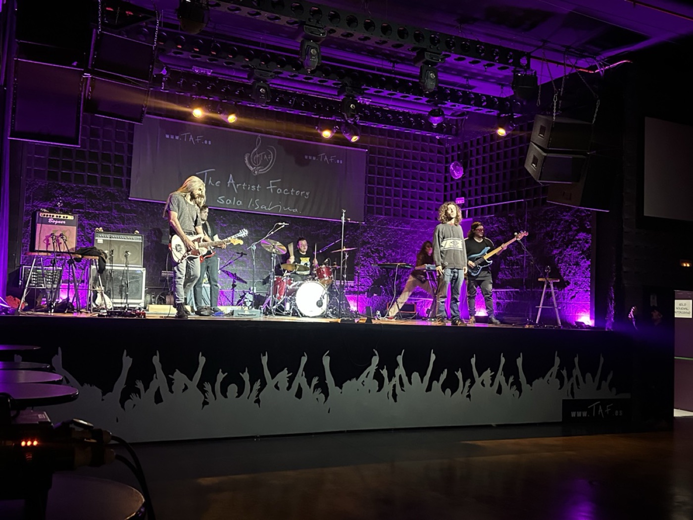 Banda tocando con luces violetas